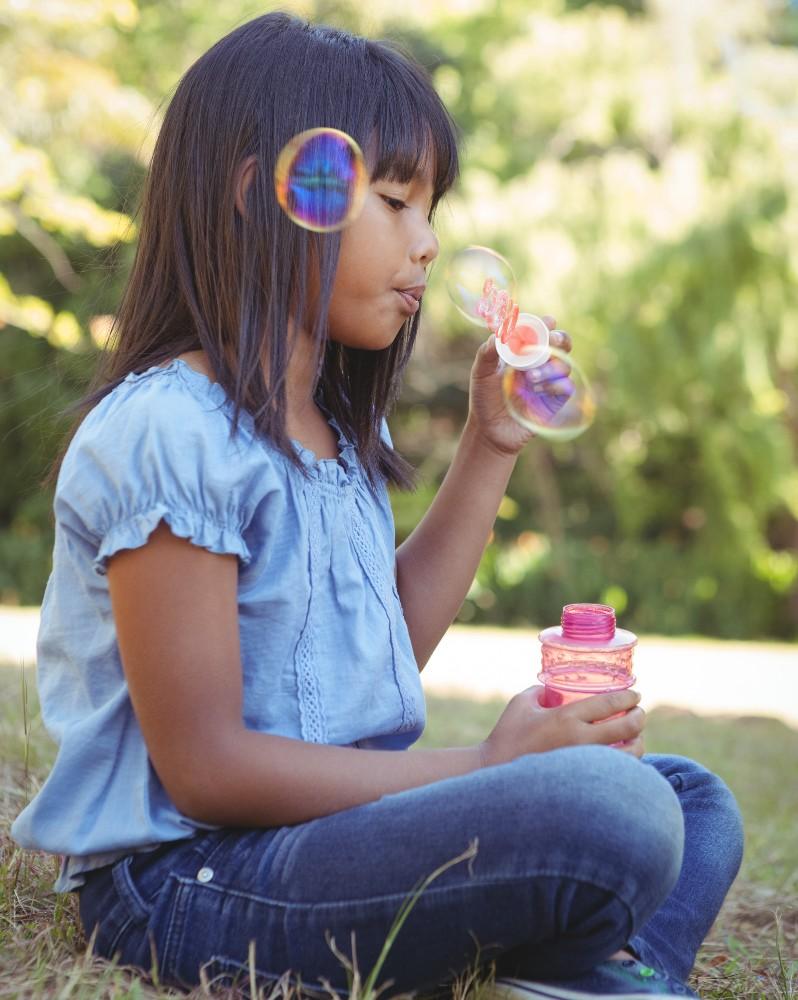A young girl blowing bubbles