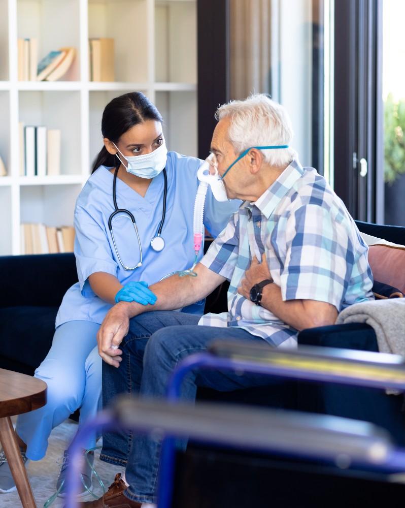 A man with an oxygen mask being supported by a HCP