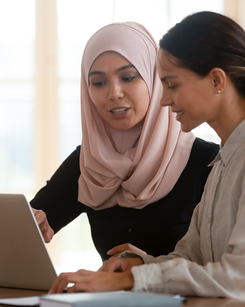 Woman wearing head covering mentoring another woman