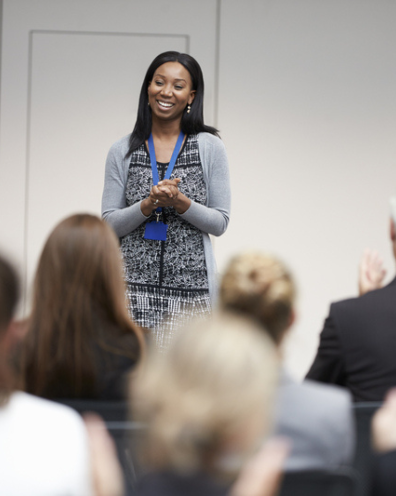 Person speaking in front of small seated crowd