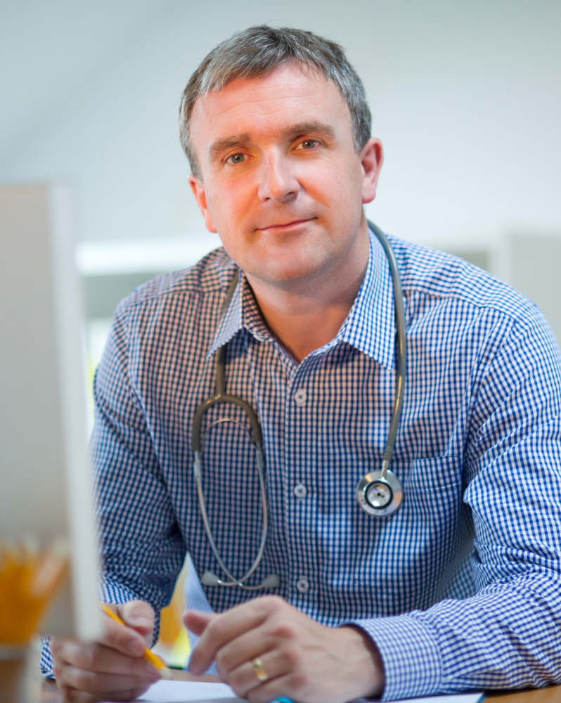 GP holding pencil wearing stethoscope