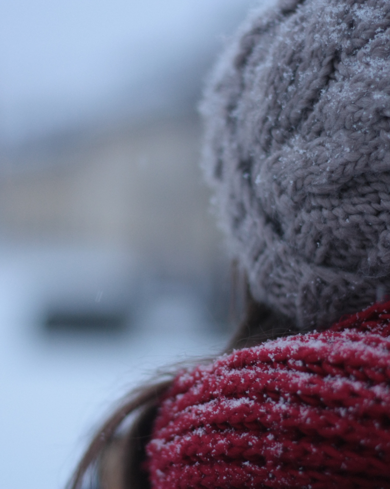 Woman wearing hat and scarf with dusting of snow