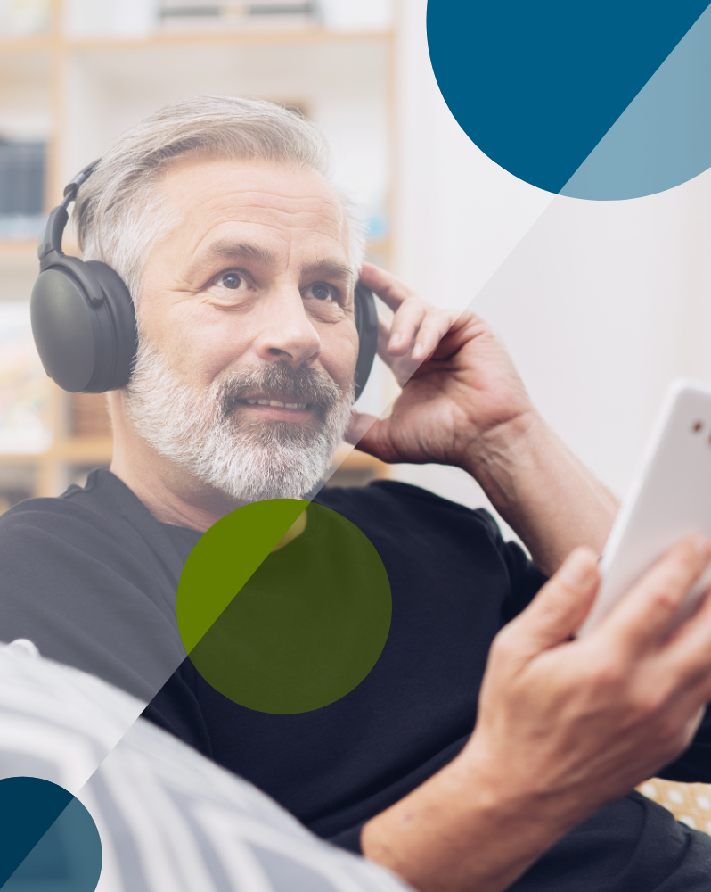A bearded man listening to headphones