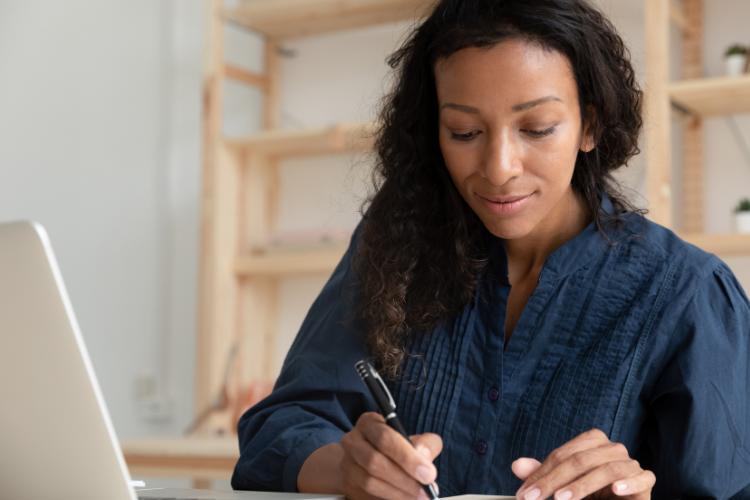 Woman taking notes during a webinar