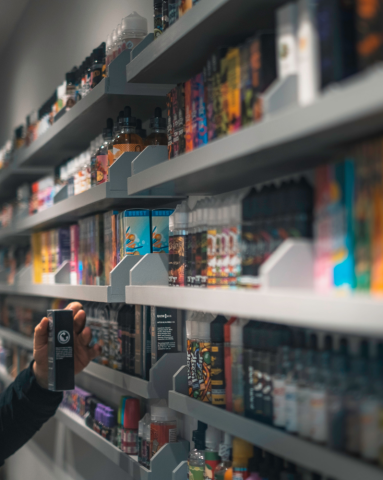 Customer selecting vape from full shelves of vaping products